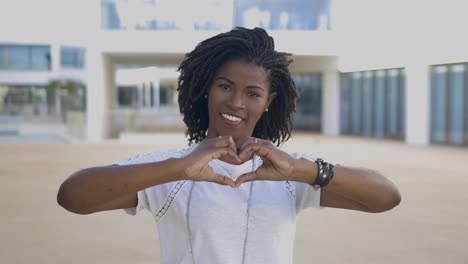 Lächelnde-Afroamerikanische-Frau,-Die-Mit-Den-Händen-Eine-Herzform-Macht.